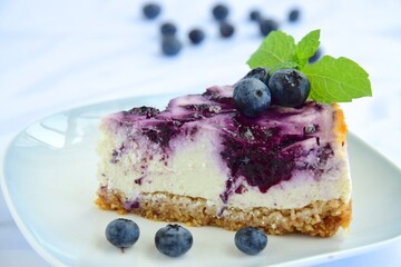 Blueberry cheesecake with mint leaf on white background. Selective focus