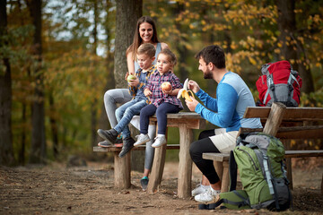 Family with children having fruit snack on outing