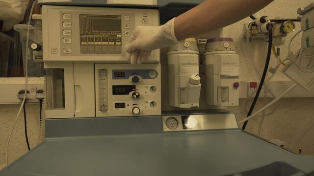 Anaesthetist doctor changing setting in anaesthetic machine work station for patient with coronavirus in hospital