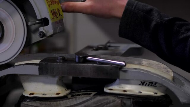 Inserting a Hockey Skate into a Sharpener Machine to Sharpen the Blade.