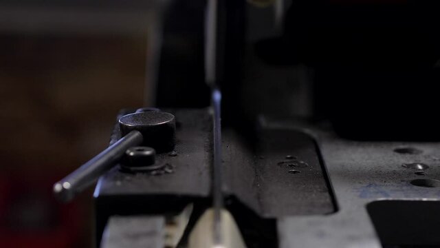 Close Up Front View of Hockey Skate being Inserted into Machine and Sharpened with Sparks Flying