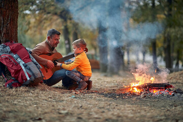 Parents with children preparing fire in wood