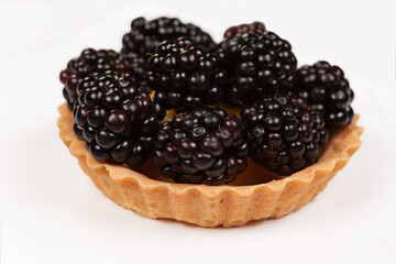 Tartlet cake with fresh blackberries. Isolated on white background