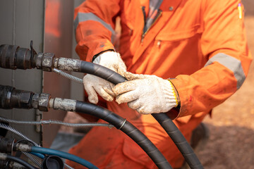Action of worker hand is connecting and checking to high-pressure hydraulic hose line of  power...