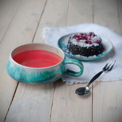 Creative layout made of cup of herbal tea on a wooden background and cupcake. Top view.