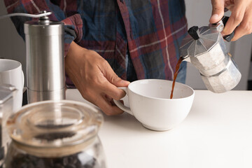 The professional of a barista poured milk. making hot coffee with equipment, tool brewing on bar at kitchen home
