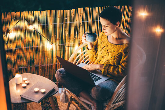  Woman Using Laptop At Balcony Of Her Apartment At The Night.