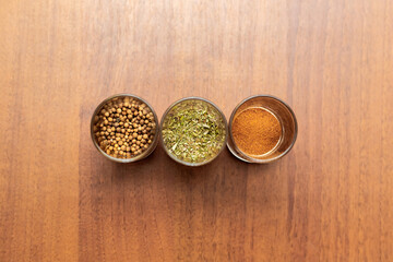 Spices for cooking, isolated on a wooden table.