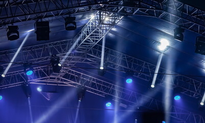 Spotlights on metal trusses at a concert at night