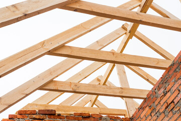 Installation of wooden beams at construction the roof truss system of the house.