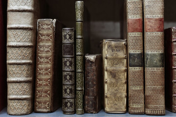 Old worn books on a shelf in the library's shelfs