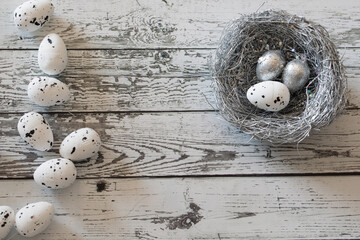Happy Easter. painted eggs in a silver basket with blooming flowers. Close up of a decorative nest with white eggs for the Easter holiday