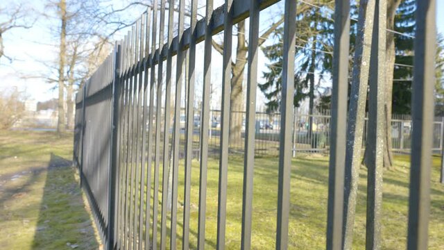 The metal fence of the house in the village with the green lawn on a sunny day