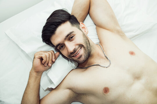 Handsome shirtless man laying on bed and have positive thinking with looking away. Seductive attitude and nice attitude sexy concept