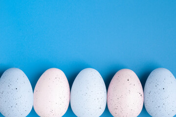 Colorful eggs on blue easter background with copy space, place for text