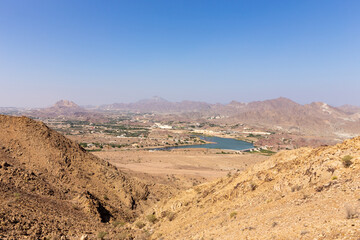 Fototapeta na wymiar Landscape of Hatta seen from giant Hatta sign in Hajar Mountains, United Arab Emirates.