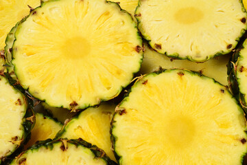 Pineapple juicy yellow slices background. Top view.