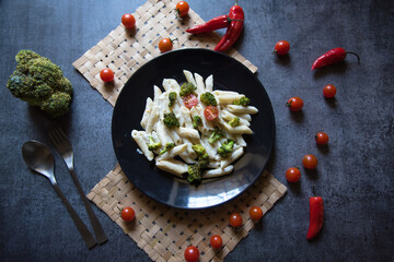 View from top of  popular Italian delicacy penne cheese pasta on a black plate