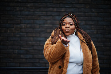 Glamorous african american woman in warm fur coat pose at street.