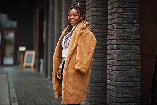 Glamorous african american woman in warm fur coat pose at street.