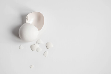 White eggshell of a broken chicken egg with shards isolated on a white background. Easter.View from above