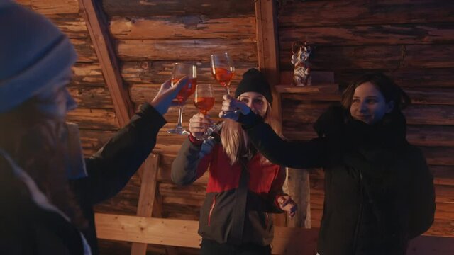 Winter vacation. Best friends making a toast in the wooden mountain cottage . High quality 4k footage