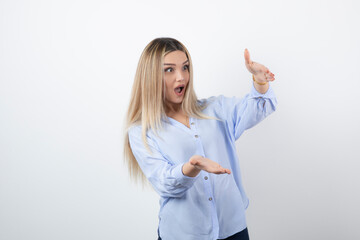 Young pretty woman standing and surprised on white background