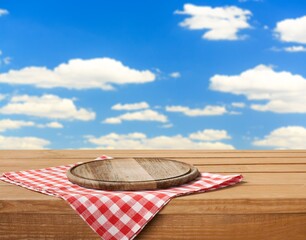 Wooden cutting board and tablecloth on wooden table