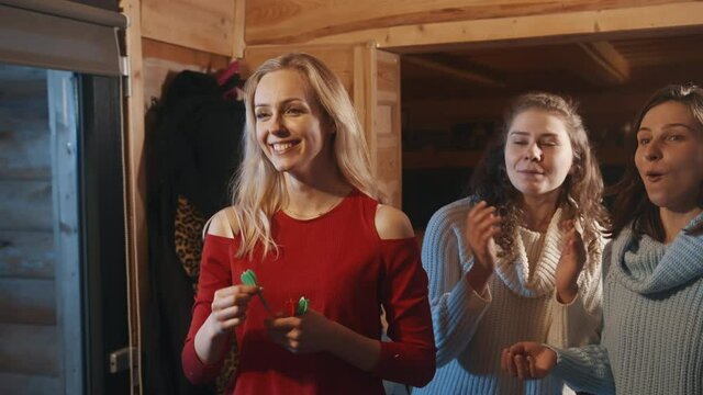Young blond woman throwing arrows into the target and friends cheering . High quality 4k footage