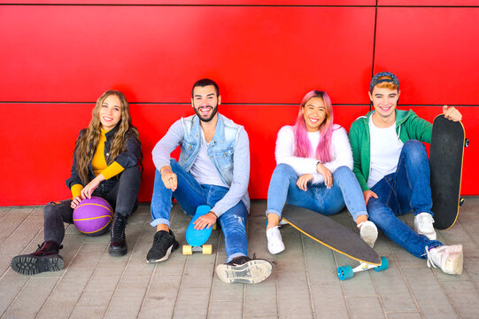 Group of students sitting on the floor outside the school - Friends with skateboard sitting at park