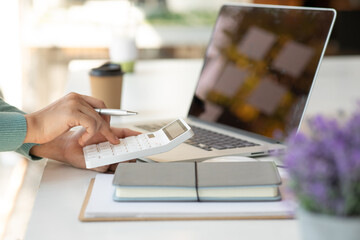Close up of Unrecognizable businesswoman using calculator.