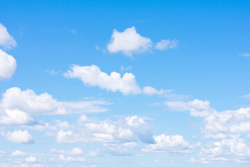 Naklejka na ściany i meble Lots of cumulus clouds far on horizon on blue daylight sky as natural background
