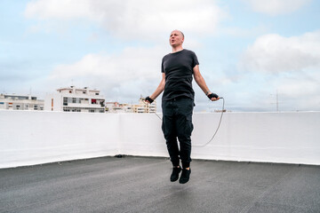 A man exercising on the rooftop using jumping rope during the lockdown