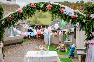 Wedding arch made of spruce, flowers and balloons