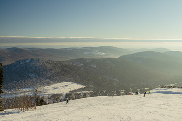 Fototapeta premium a panorama, a view from the top of the mountain to people chipping in them along the slope, you are walking on February 15, 2021