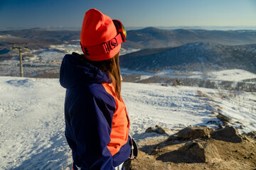 Fototapeta na wymiar girl standing on top of the mountain enjoying the view, hiking