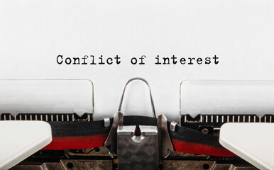 Text Conflict of interest typed on retro typewriter