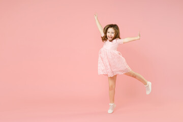 Full length of little kid girl 5-6 years old wears rosy dress have fun dancing fooling around celebrate play isolated on pastel pink background child studio portrait. Mother's Day love family concept.