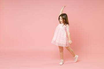 Full body length little cute kid girl 5-6 years old wears rosy dress have fun walk go step isolated...