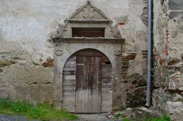 Fototapeta na wymiar old wooden door in the wall with an arch, Banská Stiavnica, Slovakia,