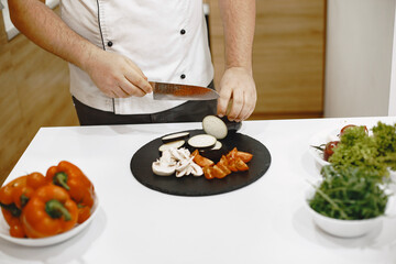 Taking care of his health. Handsome guy standing in the kitchen at home.