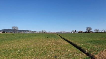 Landscape of the fields in a winter sunny day with the city of Perugia in the background 
