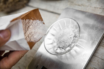 a bowl on a scale is getting filled with gypsum