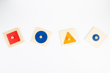 Colorful wooden Montessori sensorial material learning educational toys on white background. Geometric shape sorting board toys for baby kids. Top view