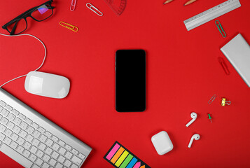 Mockup of smart gadgets on the background of office items on red background. Computer mouse and keyboard, headphones, office tools and powerbank. Top view with copy space, flat lay. Woman devices