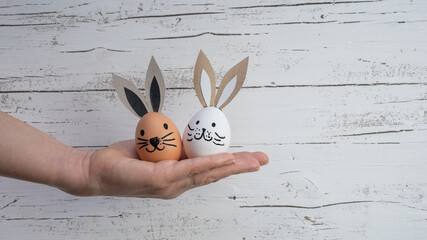 Happy Easter background greeting card - Young women holding funny cute Easter eggs with bunny ears...