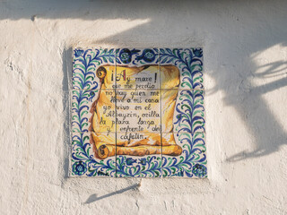 Tiles with old paper roll painted on it and spanish text on the wall in the Albaicin, Granada, Spain