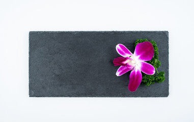 Black slate tray decorated with orchids and parsley