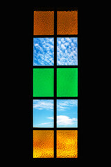 vertical window of stained glass colored with blu sky view and black framing 