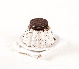 Creamy jelly with chocolate vanilla cookies on a plate on a white background